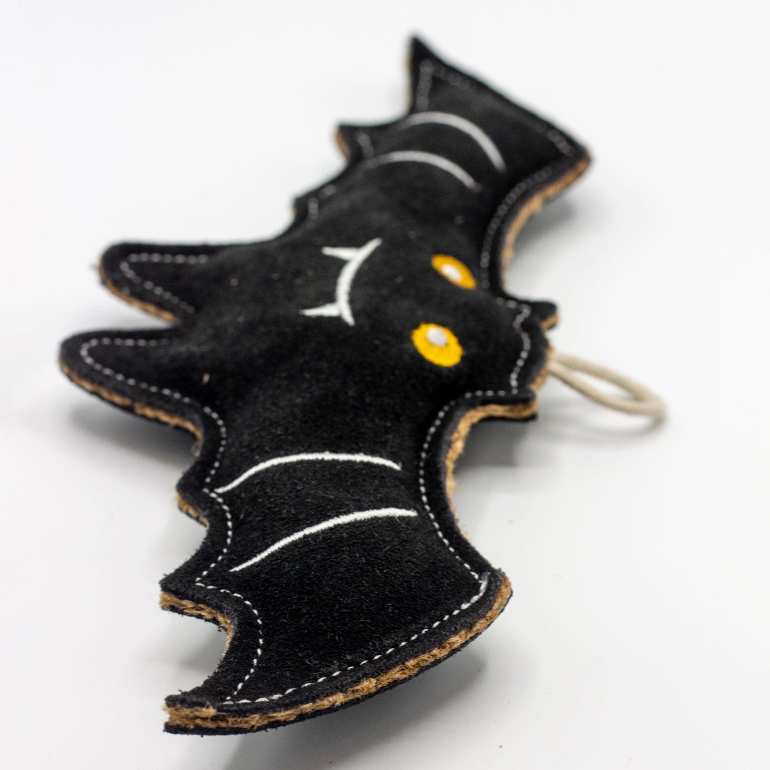 Black bat-shaped dog toy with yellow eyes