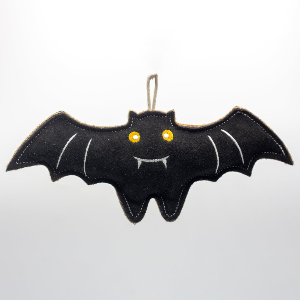 Black bat-shaped dog toy with yellow eyes