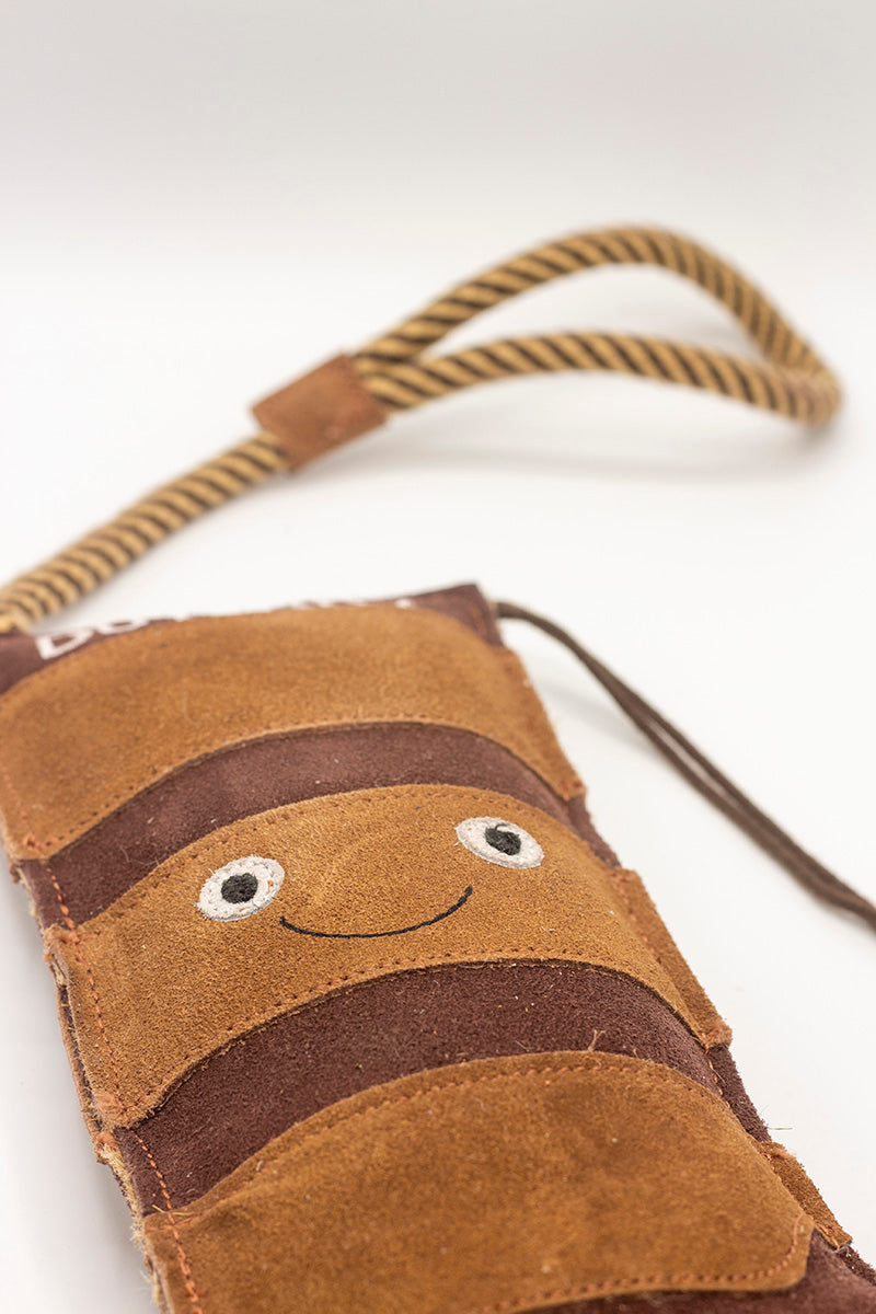 Brown boot-shaped dog toy with 'Duterry' written on it from green and wilds