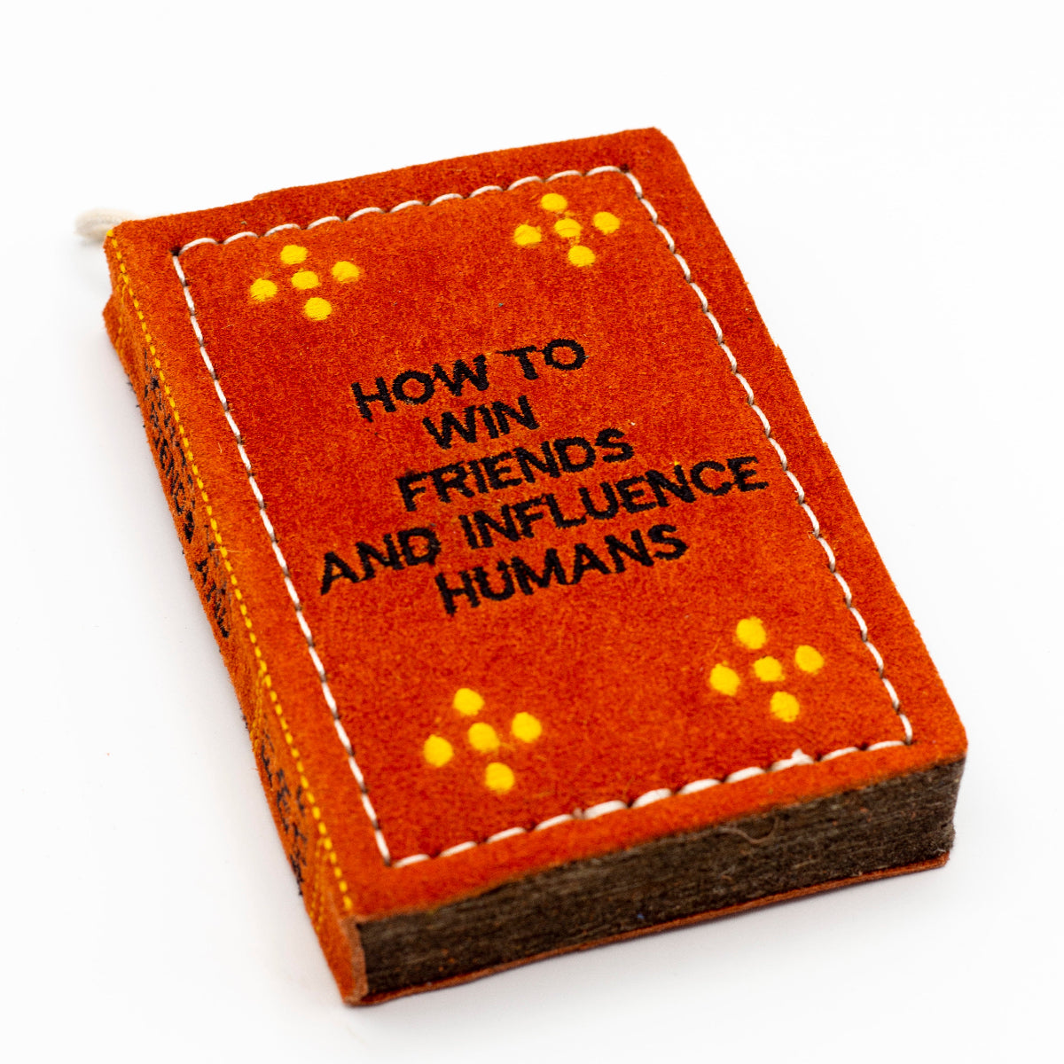 book-shaped dog toy with 'How to Win Friends and Influence Humans' text