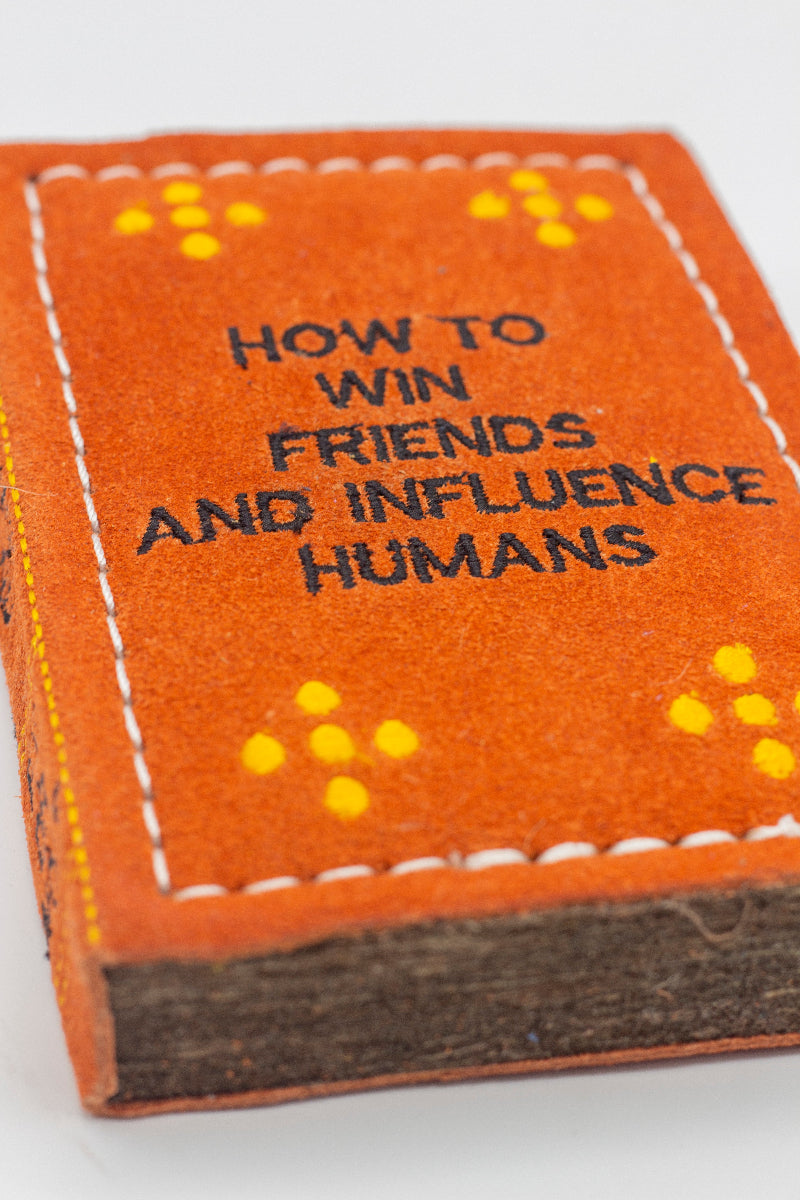 book-shaped dog toy with 'How to Win Friends and Influence Humans' text