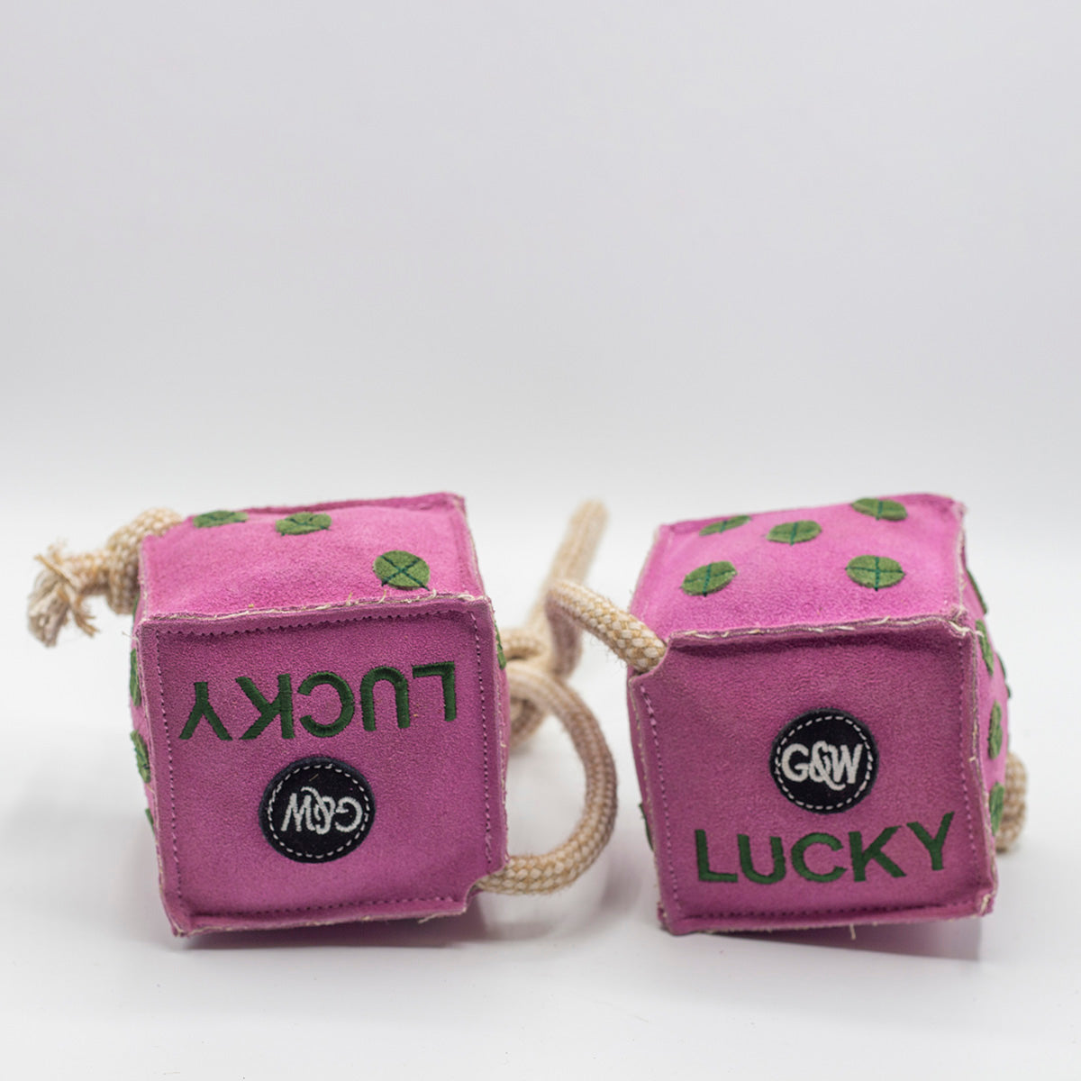 Pink dice-shaped horse and dog toy with green numbers and a rope