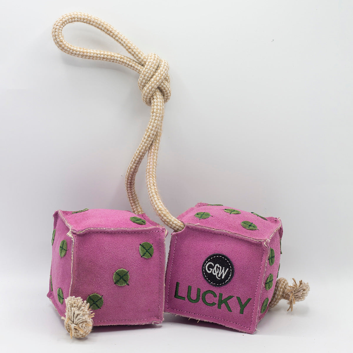 Pink dice-shaped horse and dog toy with green numbers and a rope