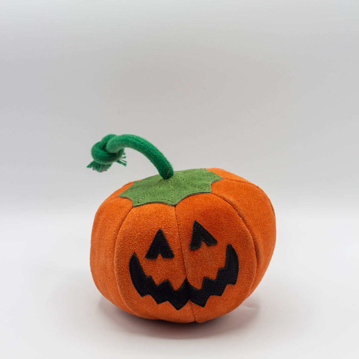 Pumpkin dog toy with a jack-o'-lantern face