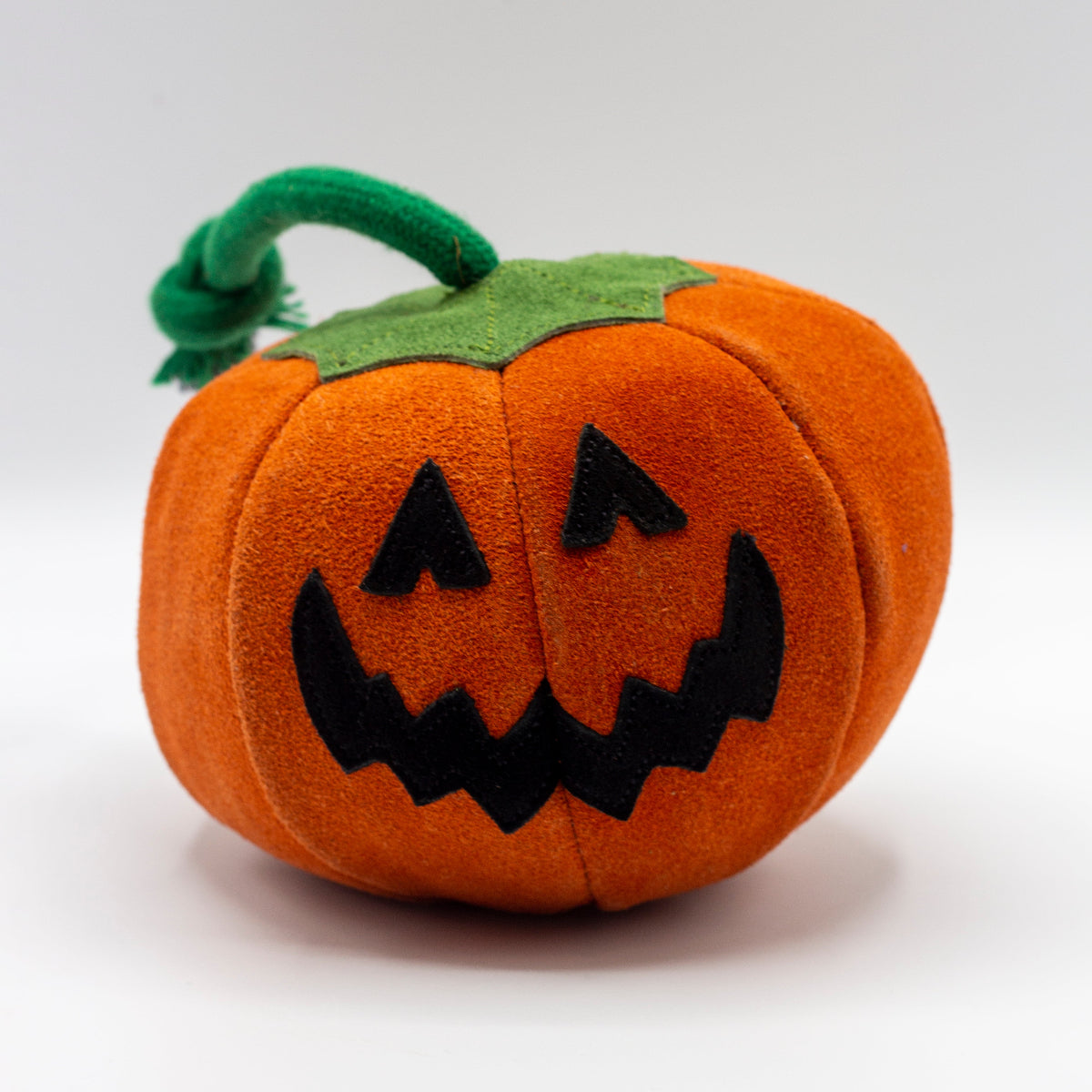 Pumpkin dog toy with a jack-o'-lantern face