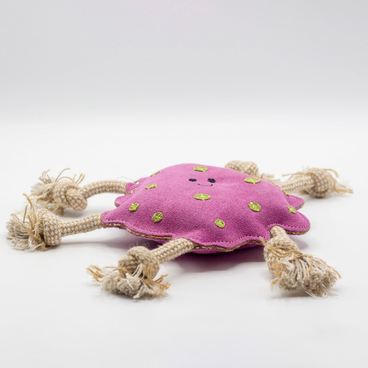 Pink suede dog toy with green spots and beige rope handles