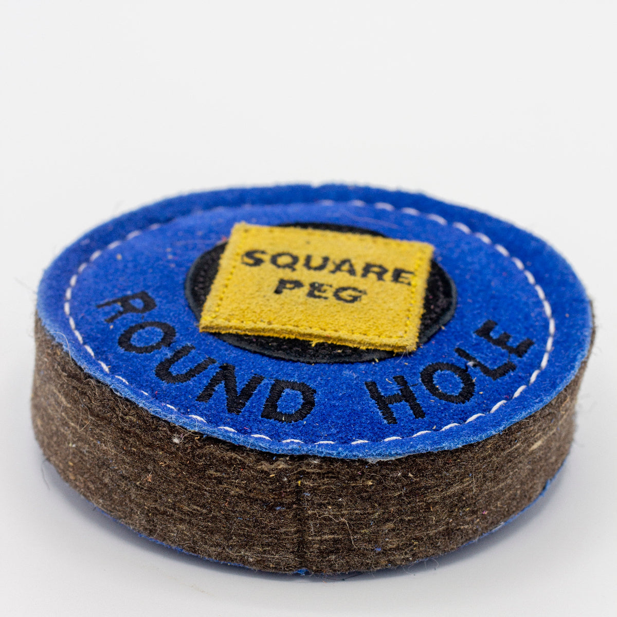 Blue circular dog toy labeled 'round hole' with a yellow square labeled 'Square Peg' inside