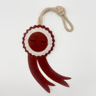 Green and wilds dog toy shaped as a red rosette