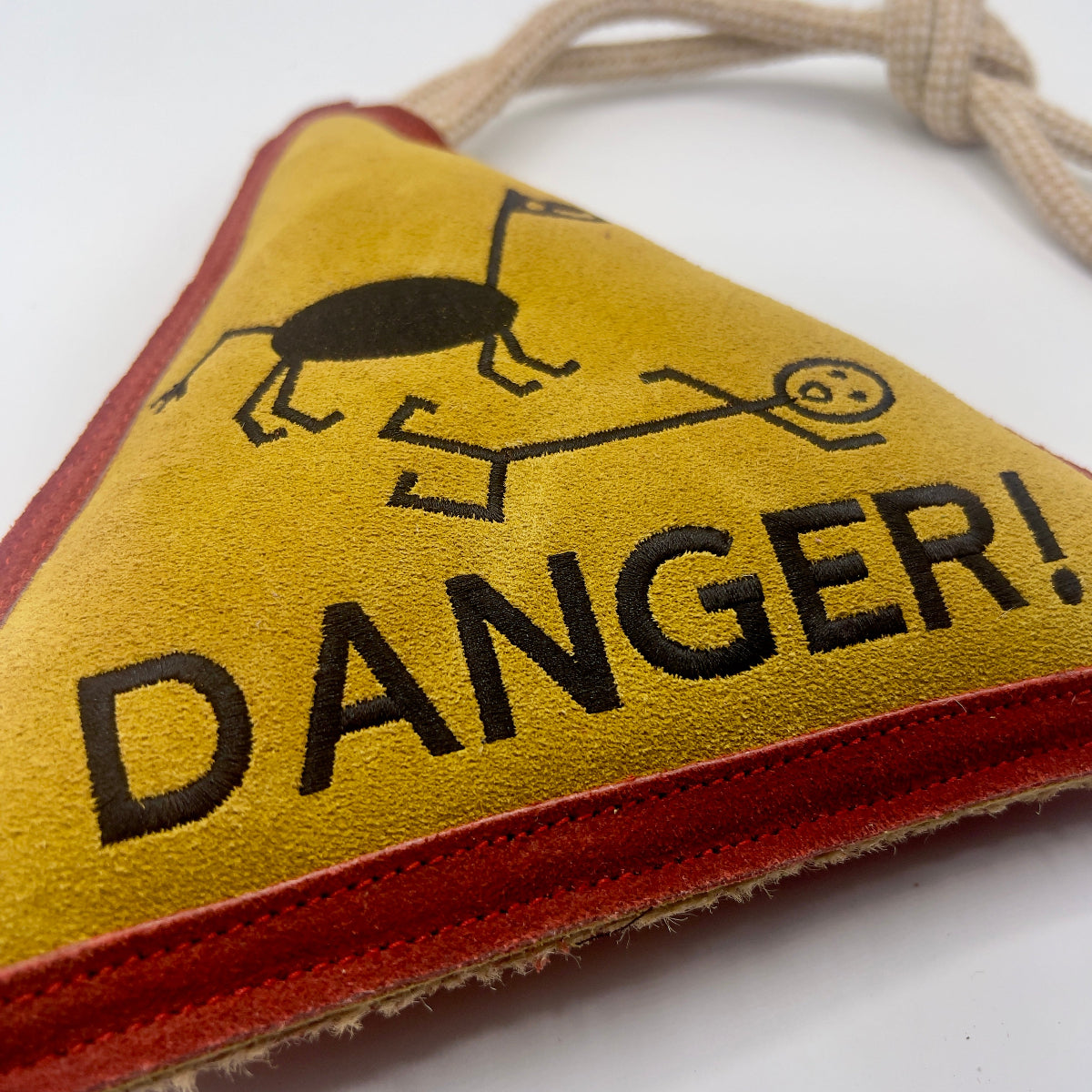 Triangle-shaped horse and dog toy with 'Danger!' warning sign and rope