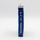 dog toy the shape of ablue book with 'A-Z of Humans' text 