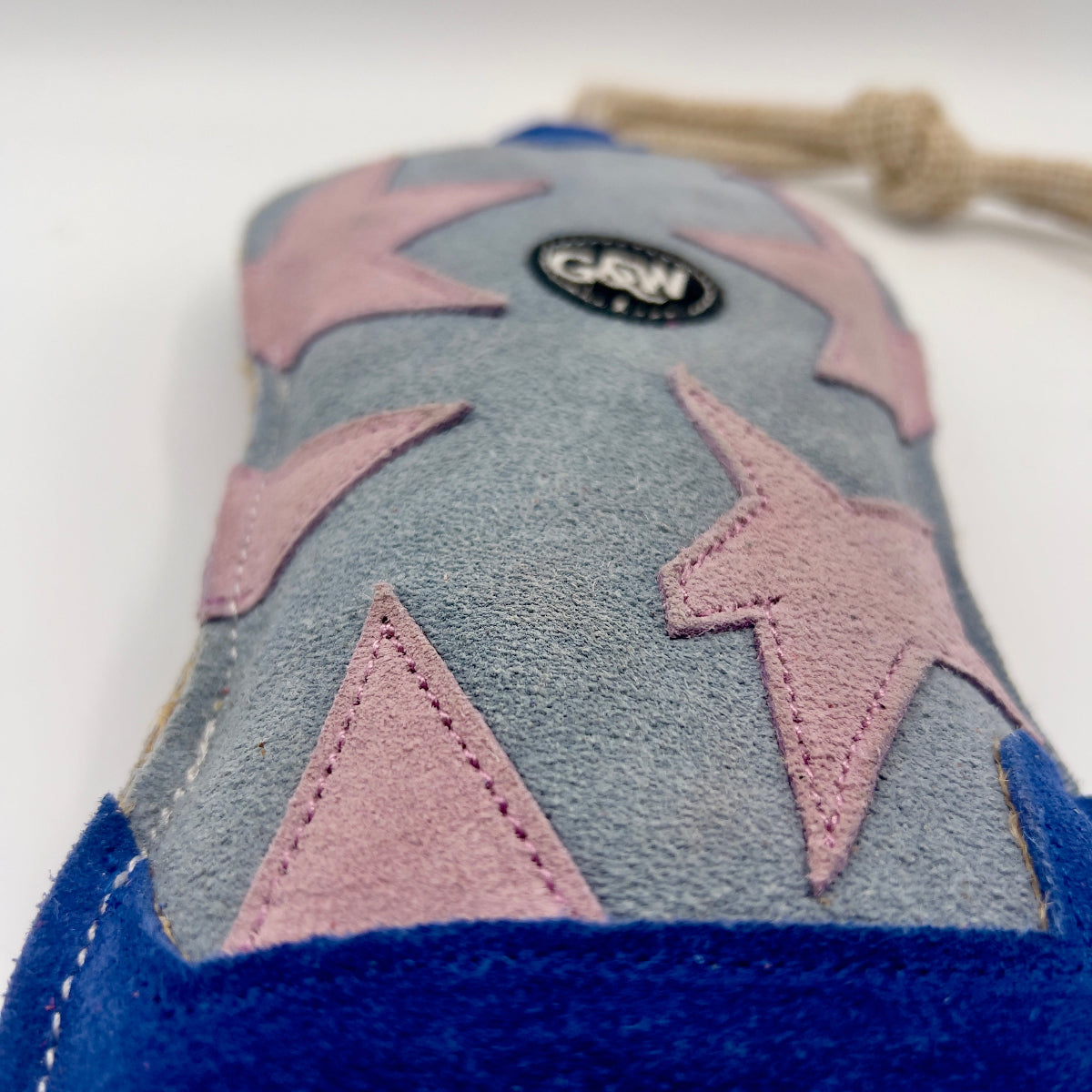 Blue and grey cowboy boot-shaped dog toy with pink stars