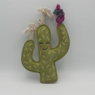 Green cactus-shaped dog toy with a smiling face