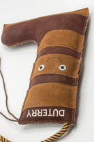 Brown boot-shaped dog toy with 'Duterry' written on it from green and wilds