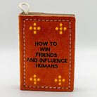 book-shaped dog toy with 'How to Win Friends and Influence Humans' text