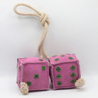 Pink dice-shaped horse and dog toy with green numbers and a rope