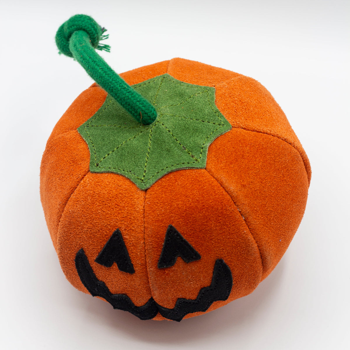 Pumpkin dog toy with a jack-o'-lantern face
