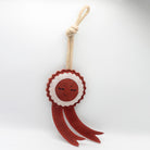 Green and wilds dog toy shaped as a red rosette