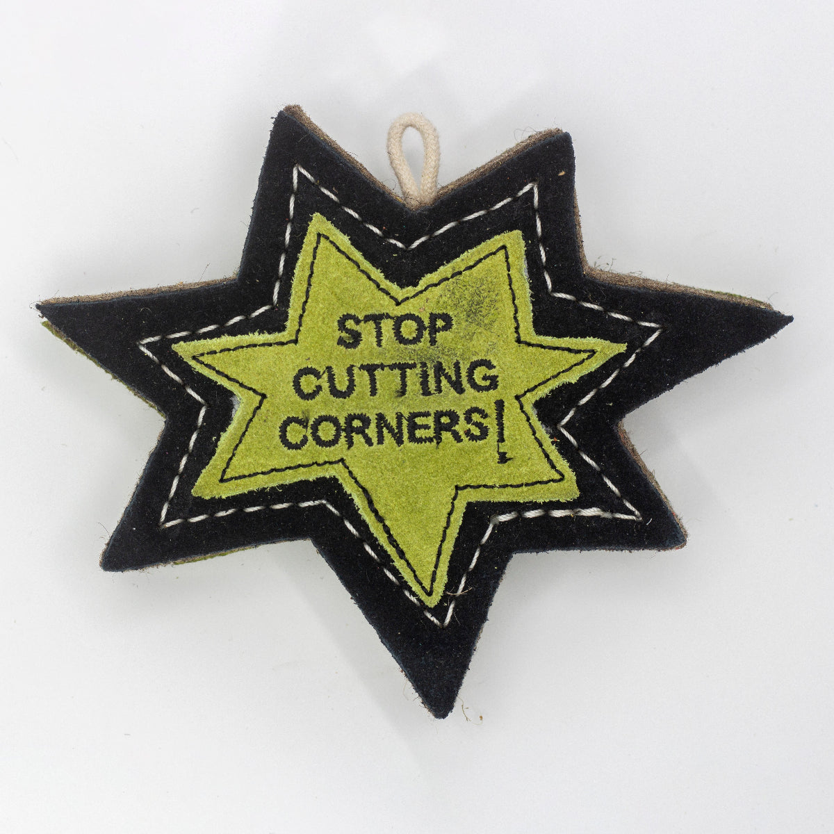 Star-shaped patch dog toy with 'Stop Cutting Corners!' text on it