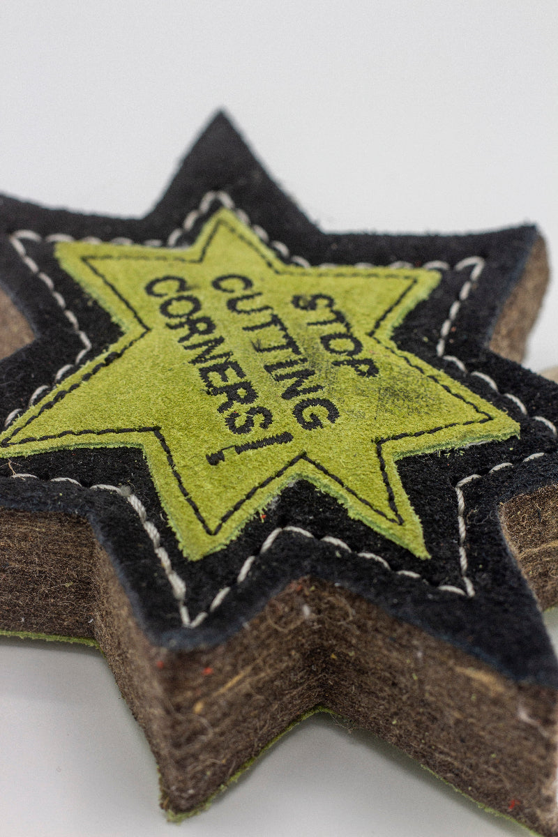 Star-shaped patch dog toy with 'Stop Cutting Corners!' text on it