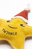 Star-shaped Christmas dog toy with a red Santa hat and 'Twinkle' text on a white background