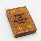 book-shaped dog toy with 'WHERE DO Squirrels LIVE?' text 