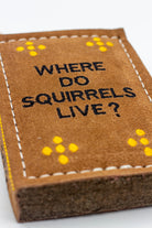book-shaped dog toy with 'WHERE DO Squirrels LIVE?' text 